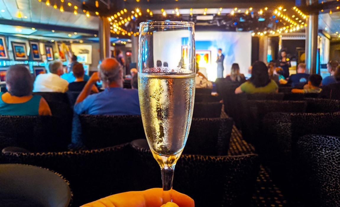 you can get a free glass of champagne at cruise ship art auctions