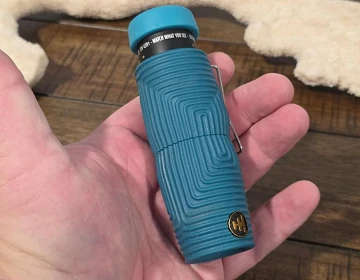 Nocs Provisions Zero Tube 8x25 monocular in teal Wave Armor held in one hand