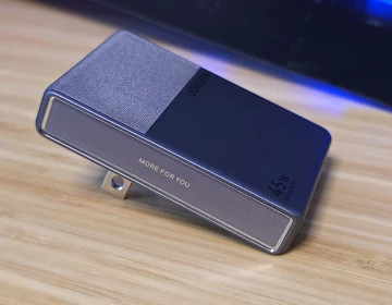 The UGREEN Nexode Air Slim 45W charger lying flat on a bamboo surface, showing its thin profile and folding prong